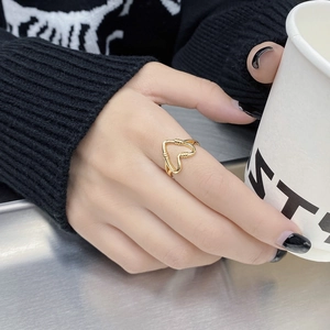 Minimalist gold heart-shaped ring with wire wrap detail shown in a lifestyle setting