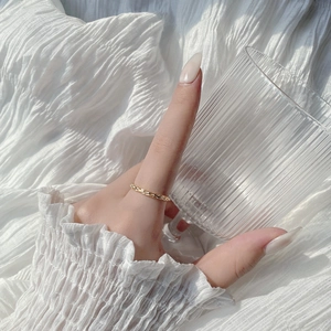 Minimalist S925 sterling silver twisted rope ring in gold on a white textured backdrop