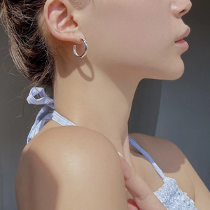 Créoles minimalistes en argent sterling S925 en forme de C portées par un mannequin chic
