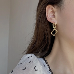 Side view of a female model wearing gold irregular geometric hollow earrings in S925 silver