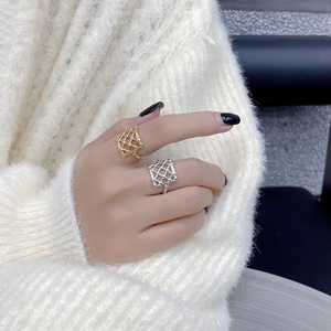 Close-up of gold and silver S925 geometric hollow mesh rings worn by a model