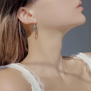 Close-up of minimalist S925 sterling silver interlocking double hoop earrings on model