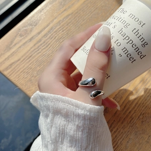 Close-up of minimalist S925 sterling silver waterdrop ring on finger with soft sunlight