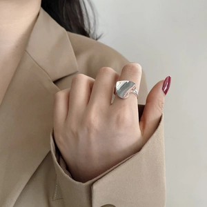 Detailed view of a polished S925 sterling silver heart-shaped ring on index finger