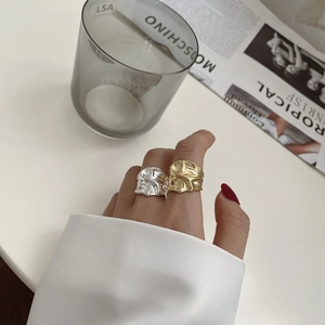 Detail of gold and silver S925 rings with irregular crinkle texture on hands