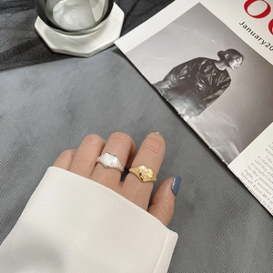 Close-up of vintage heart ring with engraved R letter and floral side patterns