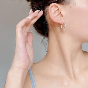 Chic S925 sterling silver twisted hoop earrings worn by a model for a minimalist look