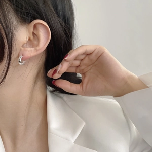 Boucles d'oreilles créoles en argent S925 avec texture spirale portées par un mannequin