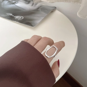 Close-up of minimalist S925 sterling silver hollow oval ring worn on index finger