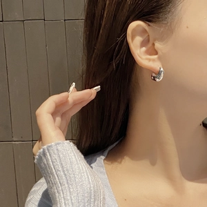 Close-up of minimalist S925 sterling silver bean hoop earrings on a model ear