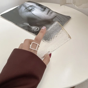 Nahaufnahme eines minimalistischen hohlen geometrischen Quadrattrings aus 925 Silber