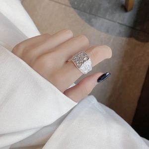 Detail of wide S925 silver ring featuring industrial lava texture on model hand