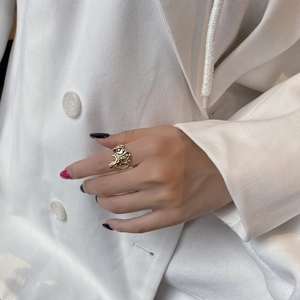 Detail of s925 silver golden irregular lava style ring with hammered texture worn by a model