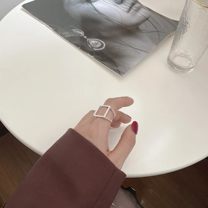 Detail eines minimalistischen quadratischen Silberrings am Finger mit modernem Design