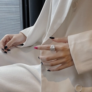 Chic S925 silver square ring with lava texture finish on a model's hand in white suit