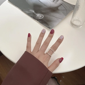 Minimalistischer geometrischer Ring aus 925er Silber, getragen von einem Modell am weißen Tisch