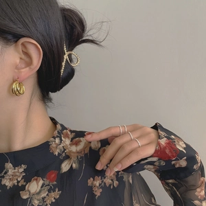 Ensemble de bagues en argent S925 et créoles dorées portées par un mannequin