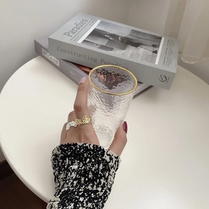 Detailed view of silver and gold irregular hammered texture rings worn on hand