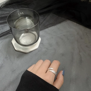Macro detail of silver adjustable ring with irregular tin foil texture on model's finger