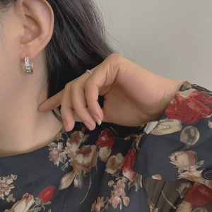 Close-up of vintage silver hollow chain link earrings worn on the earlobe