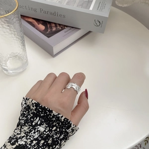 Macro detail of wide irregular 925 sterling silver ring with molten lava texture finish