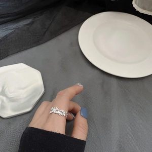 Detail view of silver ring with irregular lava texture worn on the index finger