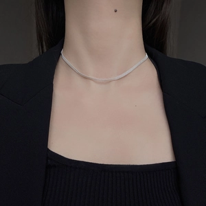 Detailed view of shimmering 925 sterling silver carved bead chain on a female neck