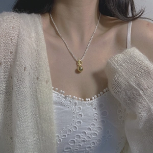 Detail of silver S925 necklace with gold sphere pendant and toggle clasp on neck