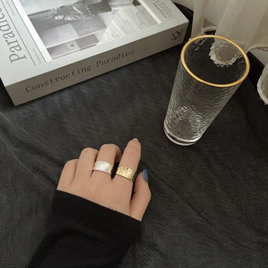 Close-up of wide S925 silver ring set with handmade hammered texture in gold and silver finish