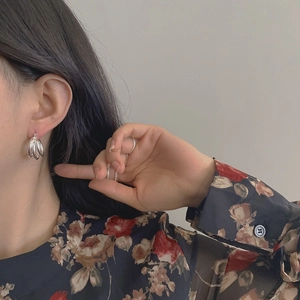 Détail de boucles d'oreilles créoles en argent S925 à trois couches sur un mannequin