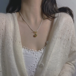 Close-up of S925 silver OT buckle necklace with golden bead pendant on model