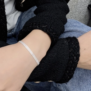 Close-up of a shimmering S925 sterling silver woven mesh bracelet on a wrist