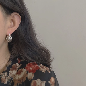 Élégantes boucles d'oreilles créoles triples en argent S925 portées par un mannequin