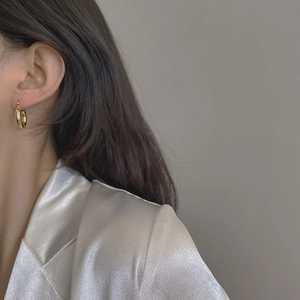 Elegant gold polished hoop earrings worn by a model for a minimalist daily fashion look