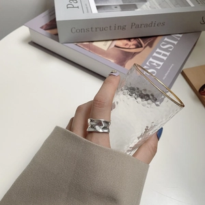 Detail view of irregular 925 sterling silver wide ring with liquid metal texture on hand