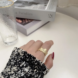 Adjustable 925 sterling silver ring with irregular gold lava texture on a model's hand