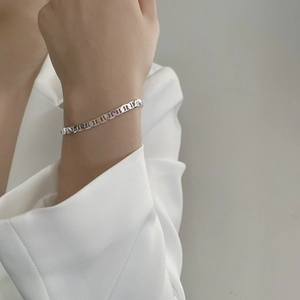 Macro shot of polished 925 sterling silver mariner link bracelet on a female wrist