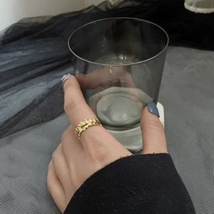Minimalist irregular wave texture ring in gold finish worn on finger for elegant styling