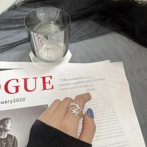 Détail d'une bague branche argentée réglable portée, sur fond esthétique élégant