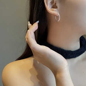 Minimalist S925 sterling silver C-shaped hoop earrings with woven texture on a female model