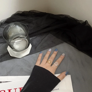 Detailansicht goldener und silberner mehrlagiger Hohlringe an den Fingern