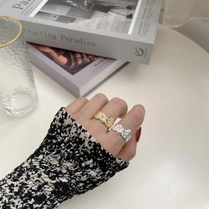 Detail of gold and silver irregular lava texture rings in a stackable open design