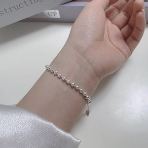 Detailed close-up of S925 sterling silver beaded bracelet with engraved texture and tag
