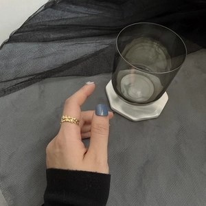 Close-up of a gold hollow butterfly ring with irregular texture worn on index finger
