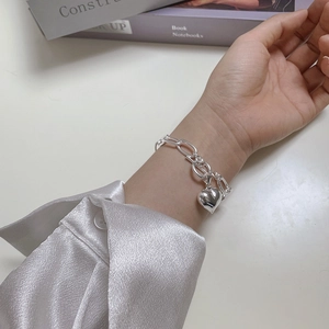 Detail of 925 sterling silver chain bracelet with a polished heart pendant and OT clasp