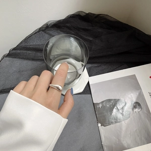 Gros plan sur bague géométrique en argent S925 avec finition miroir fluide moderne