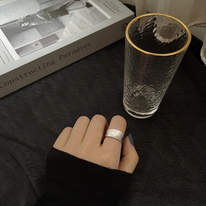 Wide S925 sterling silver ring with irregular hammered texture on a dark lifestyle background