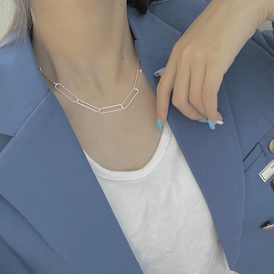 Collier chaîne trombone minimaliste en argent 925 porté par un mannequin en costume bleu
