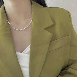 Elegant 925 sterling silver bead chain necklace worn by a model in a green blazer