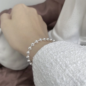 Macro shot of S925 sterling silver beaded bracelet with fine textured texture on wrist